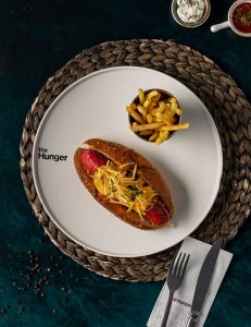 Hisə verilmiş bolonez sousu, ızqara sosis sandvic, karamelizə edilmiş soğan, kibrit kartof qızartması, ədviyyatlı kartof qızartması, çeddar sousu, xüsusi hotdoq sousu, hisə verilmiş ət.